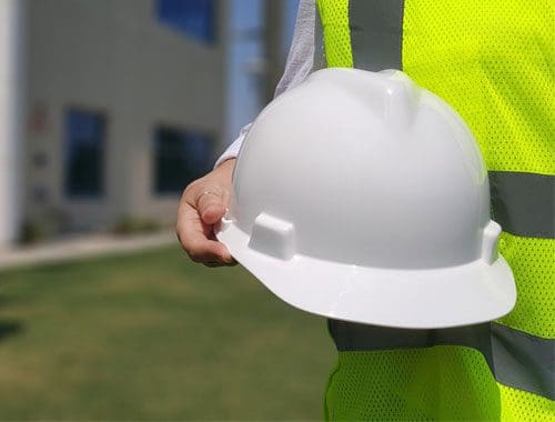 a hand holding a white hard hat