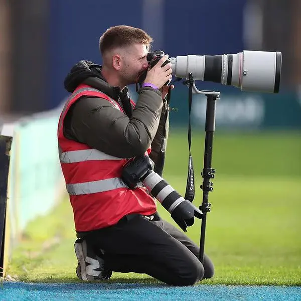 Nathan Stirk Photographer kneeling down with camera