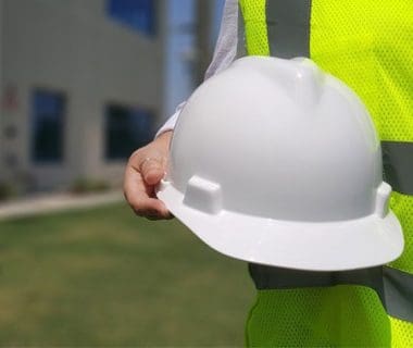 a hand holding a white hard hat